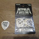 Sada kytarových trsátek v originálním balení značky Dunlop a jedno volné trsátko. Na černé kartonové obálce je bílý nápis METFIELD WHITE FANG CUSTOM…