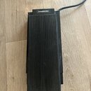 Černý obdélníkový pedál s povrchem tvořeným svislými žebrováním. V horní části je umístěn nápis HAMMOND. Z pravé strany vychází černý napájecí kabel.