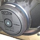 Kytarový reproduktor s černým magnetem a kovovým rámem. Na štítku je uveden nápis CELESTION GUITAR LOUDSPEAKERS, model V12-80 a impedance 8 Ohm. Dole…
