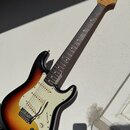 Elektrická kytara s telym v provedení sunburst a bílým pickguardem. Na hlavě hředu je viditelné logo Fender. Nástroj má tři snímače, pětistupňový pře…