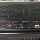 Zadní strana černého kytarového zesilovače značky Marshall. Jsou zde viditelné konektory pro FOOT CONTROLLER, LOUDSPEAKER OUTPUTS (8 Ohm a 16 Ohm), F…