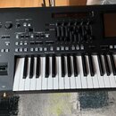 Černý digitální klavír s bílými a černými klávesami. Na ovládacím panelu jsou viditelné nápisy MASTER VOLUME, MIC, SONG A, SONG B a STYLE CONTROL. Js…