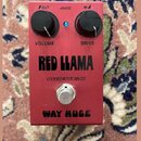 Červený kytarový efekt s nápisy RED LLAMA, OVERDRIVE MkIII a WAY HUGE. Na horní straně jsou dva černé otočné knoflíky s popisky VOLUME a DRIVE, modrá…