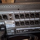 Zadní strana šedého digitálního mixážního pultu s řadou XLR výstupů označených jako OUT 3 až OUT 16. Na zařízení jsou viditelné nápisy MONITOR / CONT…