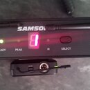 Černý bezdrátový přijímač s nápisem SAMSON a označením UHF WIRELESS RECEIVER. Na předním panelu jsou umístěny dvě antény, otočný knoflík VOLUME a tla…