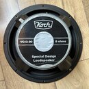 Kruhové reproduktorové jednotky s černým rámem. Na středovém štítku je bílé logo Koch a nápisy VG12-90, 8 ohms a Special Design Loudspeaker. Povrch š…