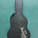 Černý tvrdý kufr na kytaru s texturovaným povrchem. Na spodní části je bílý nápis Gibson USA. Kufr má na levé straně černou plastovou rukoj.