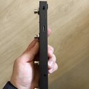 Detailní pohled na boční stranu černého elektronického zařízení. Jsou vidět čtyři kovové konektory jack, jeden USB port a dva další vstupy/výstupy. N…