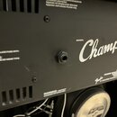 Detail zadní strany černého kytarového komba. Je zde viditelný bílý nápis MODEL Champion a logo Fender. V dolní části je text A PRODUCT OF FENDER MUS…