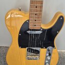 Elektrická kytara typu Telecaster s žlutým lakovaným tělem a hnědým hnedobarevným hmatníkem. Nástroj má černý plech ochranný (pickguard) a chromované…