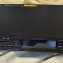 Černý rackový CD přehrávač s nápisem TASCAM CD-500B a označením MP3 WAV. Zařízení má digitální displej, ovládací tlačítka s číslicemi 0–9 a funkční p…