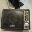 Černý reproduktor s kovovou mřížkou a ovládacím panelem vpravo. Na spodní části mřížky je bílé logo Laney a na panelu nápis CXP-10B CONCERT MONITOR.…