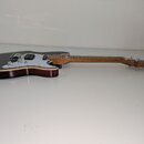 Elektrická kytara s tmavě hnědým tělem a světlou dřevěnou hmatnicí. Nástroj má bílý pickguard, dvě snímače a chromovaný most s páčkou. Na hlavě kytar…