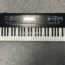 Černý digitální klavír s bílými a černými klávesami. Na levé straně je bílý nápis Roland JUNO-D. Horní panel obsahuje displej, několik tlačítek a oto…