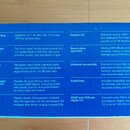 Fotografie detailu modrého informativního textu na bílém podkladu. Text je rozdělen do dvou sloupců a obsahuje technické specifikace audio zařízení,…