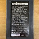 Fotografie zachycuje zadní stranu černého efektpedálu s informačním štítkem. Na štítku je uveden nápis AC ADAPTOR ENTREE ADAPTATEUR, specifikace DC-9…