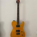 Elektrická kytara s žlutým plamenovitým povrchem těla a tmavým hmatníkem. Na hlavě je viditelné logo Fender. Kytara má tři humbuckery, dva ovládací k…