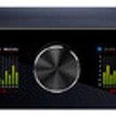 Černý rackový audio rozhraní s nápisem ORION 32+ v levé části. Uprostřed se nachází velký ovládací knoflík a dvě digitální displeje s grafickým znázo…