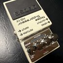 Kytarový pedál Noise Suppressor značky BOSS, model NS-1X. Zařízení je v bílém provedení s černým gumovým pedalem a čtyřmi ovládacími knoflíky. Na hor…
