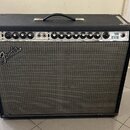 Kytarový kombo zesilovač v černém krytu s šedou textilní mřížkou. Na předním panelu je nápis Fender a vpravo označení TWIN REVERB. Ovládací panel obs…