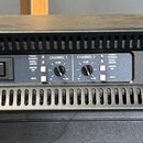 Černý rackový zesilovač s nápisem KV audio na levé straně a ESP 2000 na pravé straně. Uprostřed se nachází vypínač a dva ovratidla s označením CHANNE…