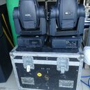 Dvě modře šedé moving head světla značky Martin, model MAC 250. Jsou umístěna na černém transportním case s kovovými hranami a zámky. Na přední stran…