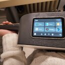 Detailní záběr na tělo kytary s tmavým povrchem imitujícím dřevo. V těle je integrovaný displej s nápisem Apps a ikonami funkcí Tuner, Effects, Pra..…