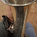 Detail stříbrného kovového zvinu trubky. Na povrchu je vyryt nápis STAR a pod ním text v několika řádcích, ze kterých jsou čitelné slova LASICE a čís…