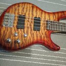 Elektrická basová kytara s tělem z plamenového javoru v červeně-žlutém gradientním lakování. Nástroj má dva černé humbuckery, čtyři chromované ovláda…