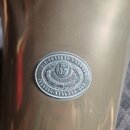 Detail kovového povrchu nástroje s kulatým vyraženým logem. V horní části okruhu je nápis V.F. CERVENY & SYNOVĚ a v dolní části HRADEC KRALOVE CSR. U…