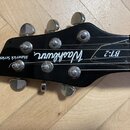 Černá hlava elektrické kytary s chromovanými ladičkami. Na povrchu je bílý nápis Maverick Series, logo Washburn a označení BT-2. Povrch vykazuje drob…