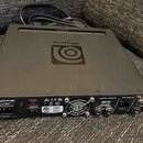 Černý basový zesilovač značky Ampeg, model PF-350. Na zadním panelu jsou viditelné vstupy a výstupy, včetně nápisů speaker outputs, XLR line out a lo…