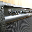 Kytarový kombo zesilovač značky CRATE s černým povrchem a tkanou mřížkou. Na ovládacím panelu je nápis 120 WATTS a vstup INPUT. Panel obsahuje tři se…