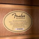 Detail vnitřní štítku akustické kytary z mahagonového dřeva. Na oválném štítku je logo Fender a nápisy ACOUSTICS, Model: CD-140S All Mahogany, Made i…