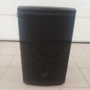 Černý reproduktor s kovovou mřížkou. V dolní části mřížky je umístěno logo JBL. Povrch vypadá čistě a bez viditelných poškození.