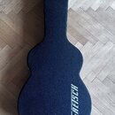 Tmavě modrý tvrdý pouzdro na kytaru v kształtu hollow-body. Na spodní části je bílý nápis GRETSCH. Povrch pouzdra má texturovanou strukturu a je v do…