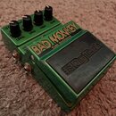 Zelený kytarový efekt s nápisem BAD MONKEY TUBE OVERDRIVE a logem Digitech na černé ploše. Na horní straně jsou čtyři černé otočné knoflíky s popisky…