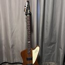 Hnědá elektrická basová kytara s bílým plechtrátorem. Na hlavě je viditelné logo Rickenbacker a na plechtrátoru je nápis Rickenbacker s doprovodným l…