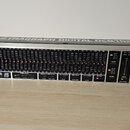 Stříbrný rackový digitální grafický ekvalizér s nápisem ULTRAGRAPH DIGITAL DEQ1024. Přední panel obsahuje řadu posuvníků s červenými LED diodami, růz…