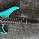 Modrá elektrická kytara s černým hmatníkem a černým pickguardem. Nástroj má jeden humbucker, pět ladicích kolínek u kobylce a bezhlavý krk. Na těle n…