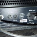 Záběr na zadní panel černého elektronického zařízení s ventilací v horní části. Jsou vidět konektory označené nápisy F/S, MIDI IN a MIDI THRU, a vstu…