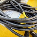 Černý svitek mikrofonního kabelu s nápisem CORDIAL MICROPHONE CABLE HIGH PERFORMANCE. Na jednom z konců je vidět konektor XLR. Kabel vykazuje běžné z…