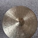Kruhové činely z mosazi s výrazným klepaným povrchem a koncentrickými drážkami. V dolní části je čitelně vyražen nápis BYZANCE a text "Hand Hammered"…