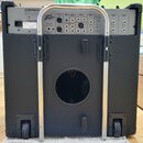 Zadní strana černého kytarového komba s kovovou madlou a kolečky. Na horním panelu je nápis PEAVEY ELECTRON CORPORATION a logo Peavey. Panel obsahuje…