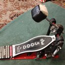Červený bubnový pedál s černým šlapadlem. Na šlapadle je bílý nápis 3000 a na jeho boku text Drummer's Choice®. Pedál vykazuje známky používání a zne…