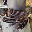 Na fotografii jsou vidět několik kusů tmavého, pravděpodobně karbonového materiálu s jemnou rýhováním. Jedna část je rovný obdélníkový panel, ostatní…