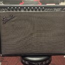 Černý kytarový kombo zesilovač s látkovou mřížkou. Na předním panelu je nápis Frontman 212R a logo Fender. V horní části jsou umístěny ovládací knofl…