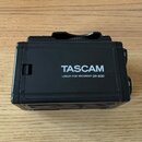 Černý digitální nahrávač s bílým nápisem TASCAM a textem LINEAR PCM RECORDER DR-60D. Zařízení je vyrobeno z plastu a vykazuje mírné známky opotřebení…