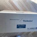 Kartonová krabice s nápisy v angličtině a francouzštině. Na povrchu je vidět logo Technics, text Rediscover Music a označení modelu SL-1200M7G. V mod…