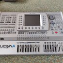 Stříbrný aranžér Ketron Audya 4 s nápisem „AUDYA 4 advanced music station“ v levém dolním rohu a logem „KETRON“ nahoře. Přístroj disponuje LCD disple…